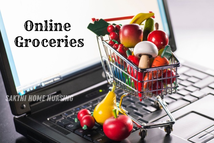 Mini shopping cart filled with fresh fruits and vegetables on a laptop keyboard, promoting Sakthi Home Nursing Service's online grocery shopping convenience in Coimbatore.